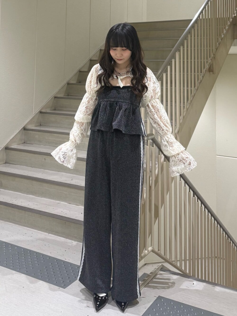 ブラック系のパンプス、ホワイト系のカーディガン/ボレロ、ブラック系のキャミソールを着用したレディースの春コーディネートの3枚目の写真