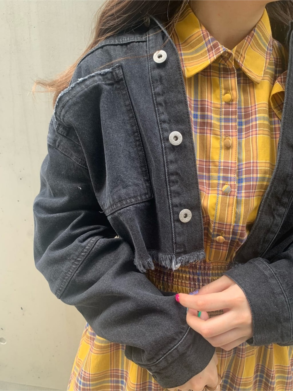 イエロー系のワンピース、ブラック系のデニムジャケット、ブラック系のサングラスを着用したレディースの春コーディネートの5枚目の写真