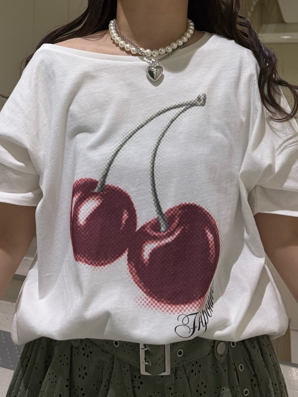 ホワイト系のTシャツ/カットソー、ブラック系のブーツ、グリーン系のスカートを着用したレディースの春コーディネートの7枚目の写真