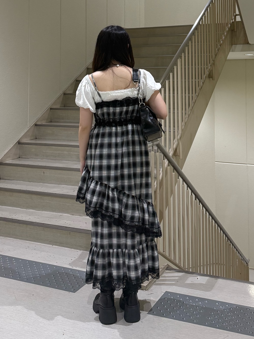ブラック系のハンドバッグ、ブラック系のブーツ、ホワイト系のシャツ/ブラウスを着用したレディースの夏コーディネートの4枚目の写真