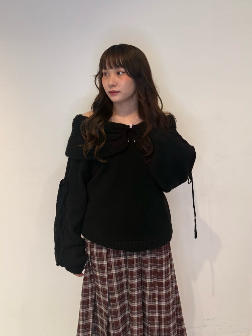 ブラック系のニット/セーター、レッド系のスカート、ブラック系のローファーを着用したレディースの秋コーディネートの5枚目の写真