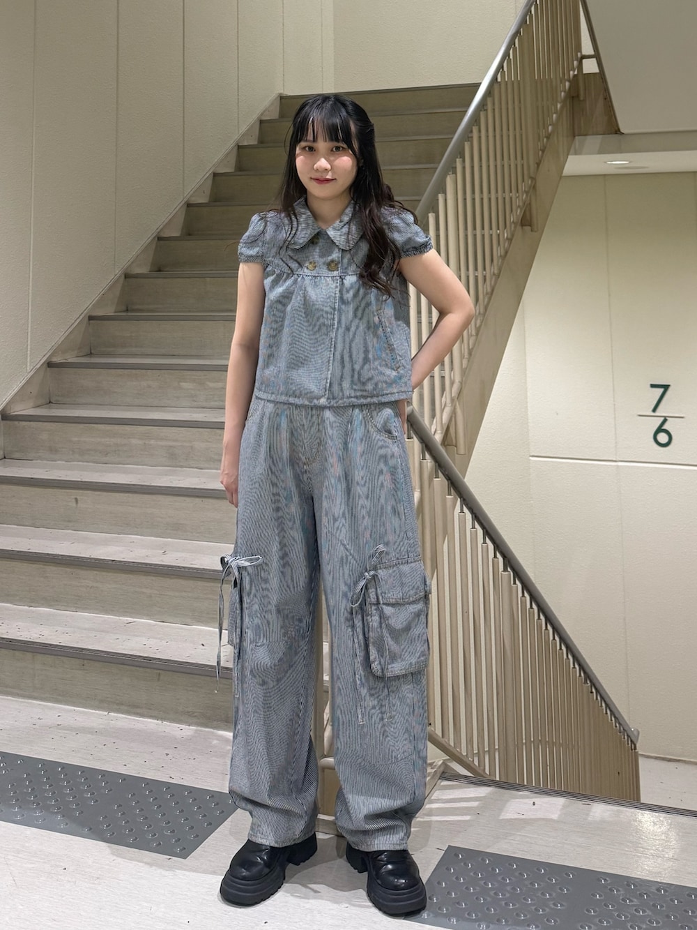 ブラック系のデニムパンツ、ブラック系のブーツ、ブラック系のその他トップスを着用したレディースの春コーディネートの3枚目の写真