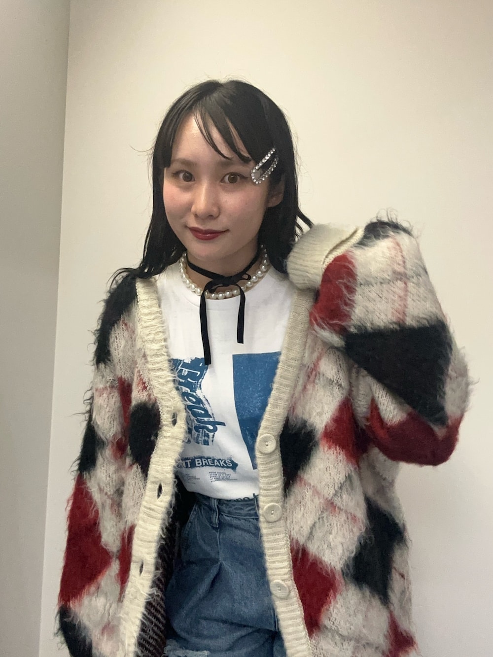 ホワイト系のカーディガン/ボレロ、ホワイト系のTシャツ/カットソー、ブルー系のデニムパンツを着用したレディースの秋コーディネートの5枚目の写真