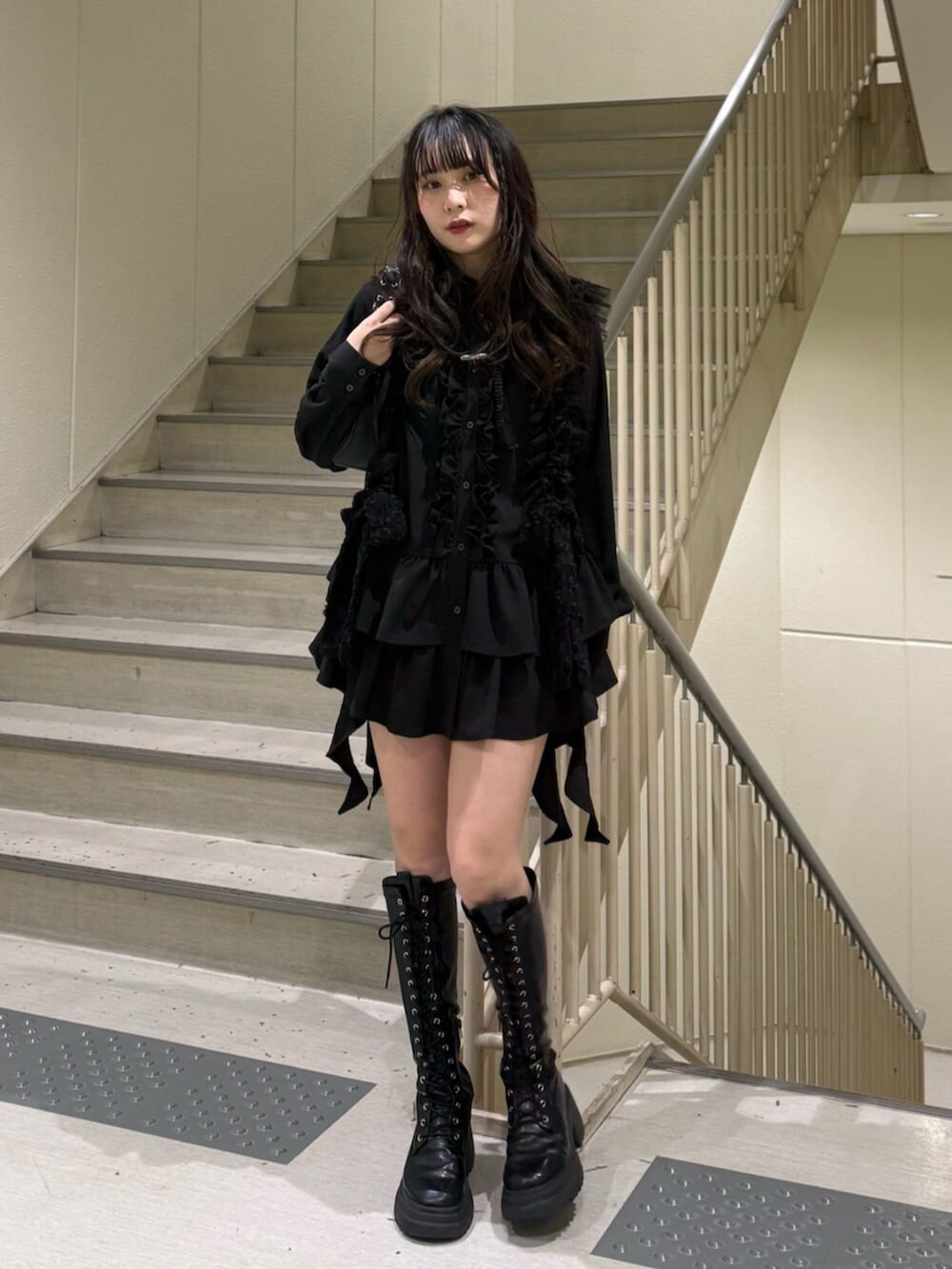 ブラック系のブーツ、ブラック系のハンドバッグ、ブラック系のシャツ/ブラウスを着用したレディースの冬コーディネートの2枚目の写真