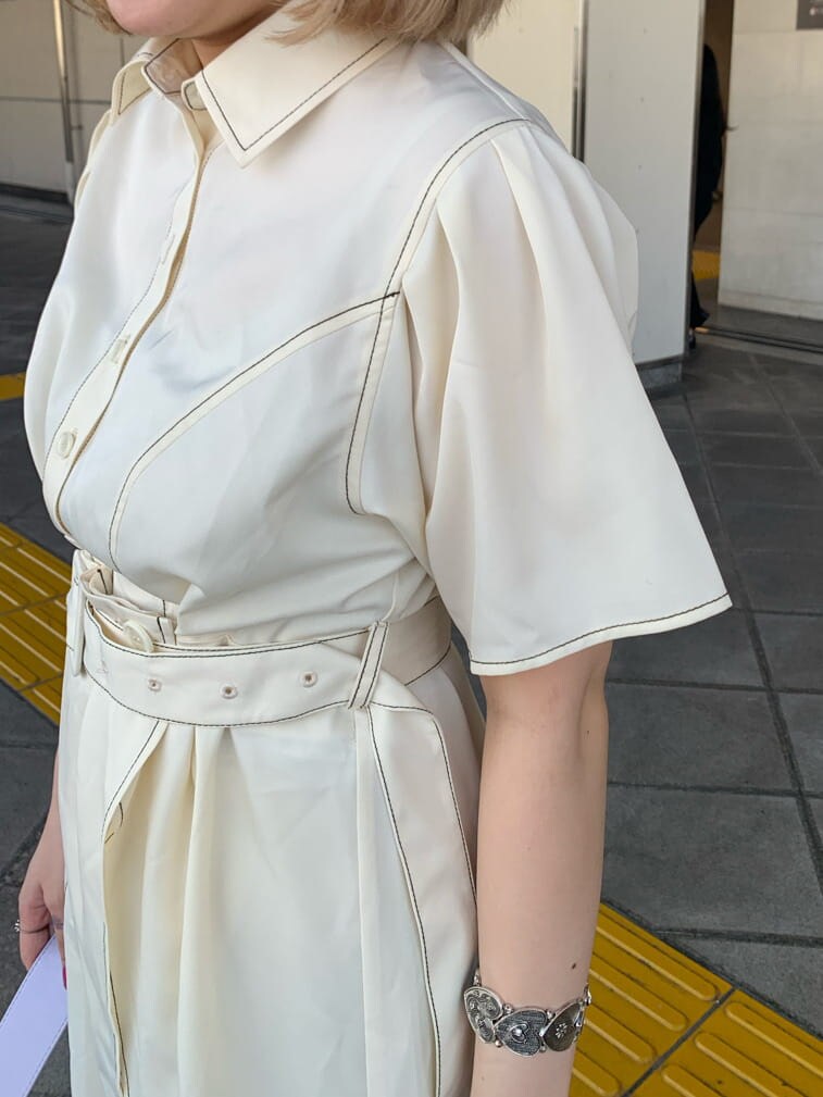 パープル系のハンドバッグ、ホワイト系のワンピース、シルバー系のブレスレットを着用したレディースの夏コーディネートの4枚目の写真