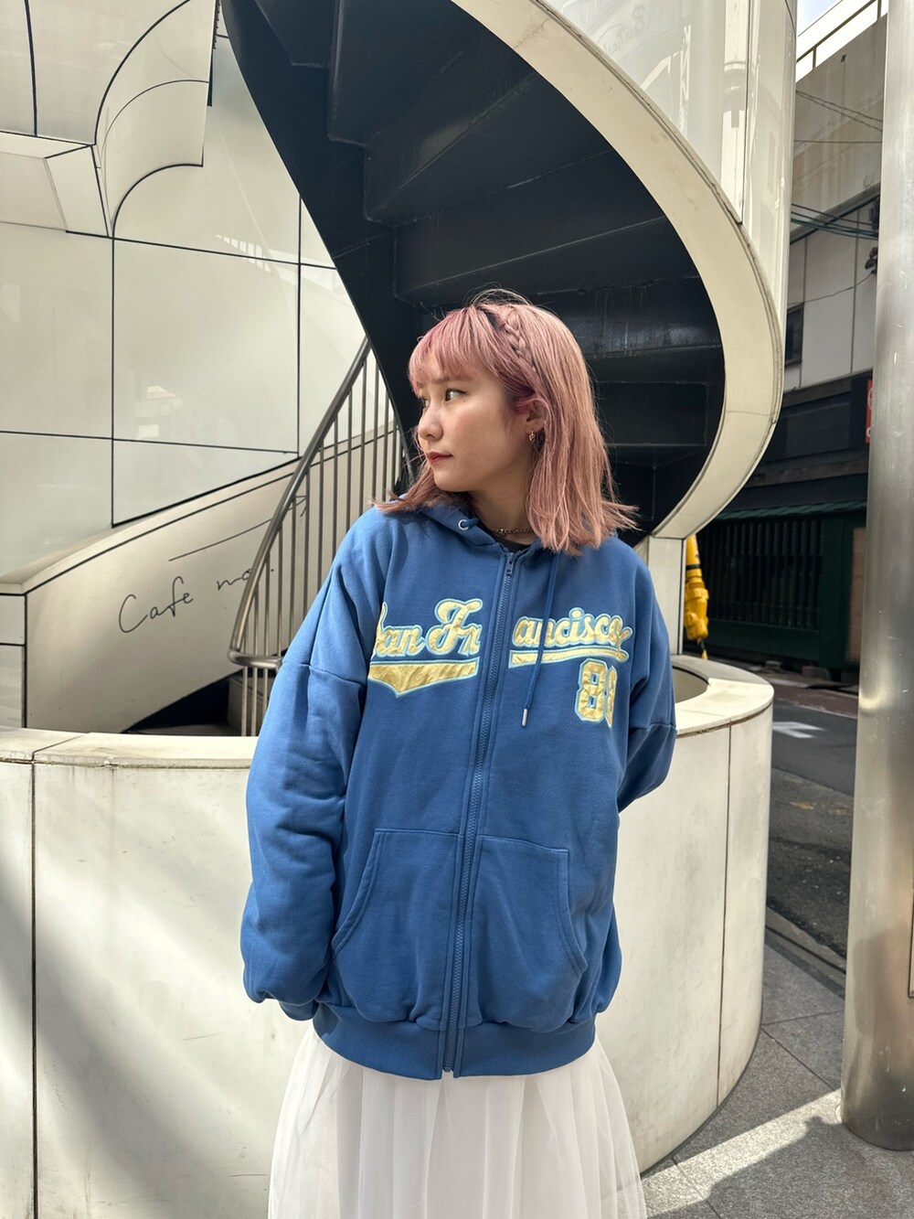 ブルー系のパーカー、ホワイト系のスカート、ブラック系のブーツを着用したレディースの春コーディネートの4枚目の写真