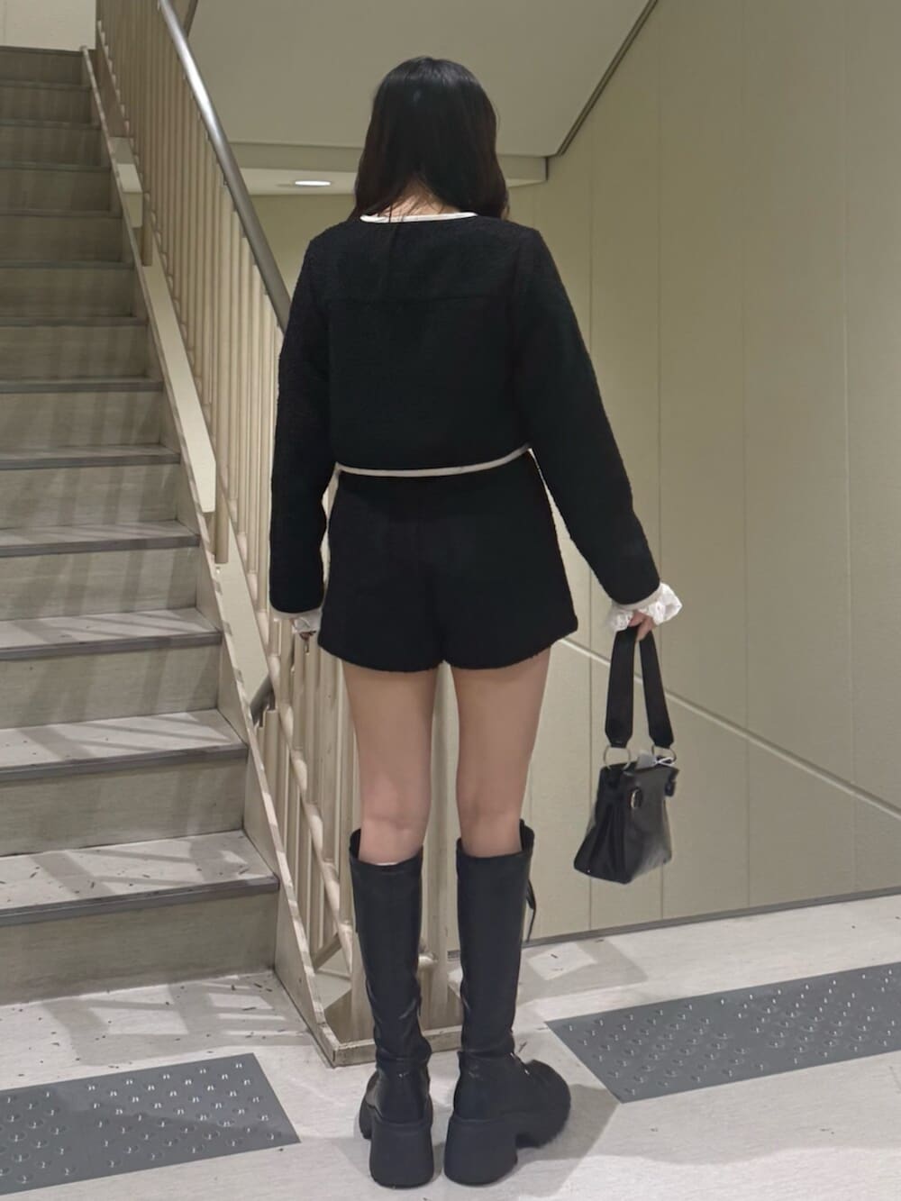 ブラック系のブーツ、ブラック系のノーカラージャケット、ブラック系のその他パンツを着用したレディースの冬コーディネートの5枚目の写真