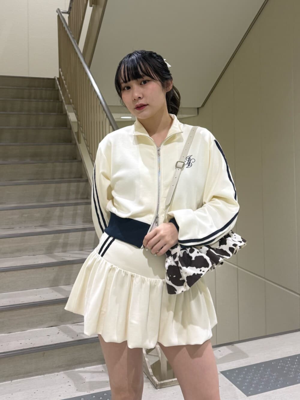 ブラック系のブーツ、ホワイト系のジャージ、ホワイト系のスカートを着用したレディースの冬コーディネートの7枚目の写真