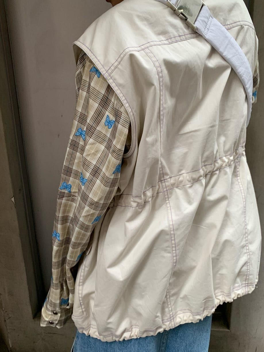 ブルー系のデニムスカート、ベージュ系のシャツ/ブラウス、ホワイト系のベストを着用したレディースの秋コーディネートの5枚目の写真