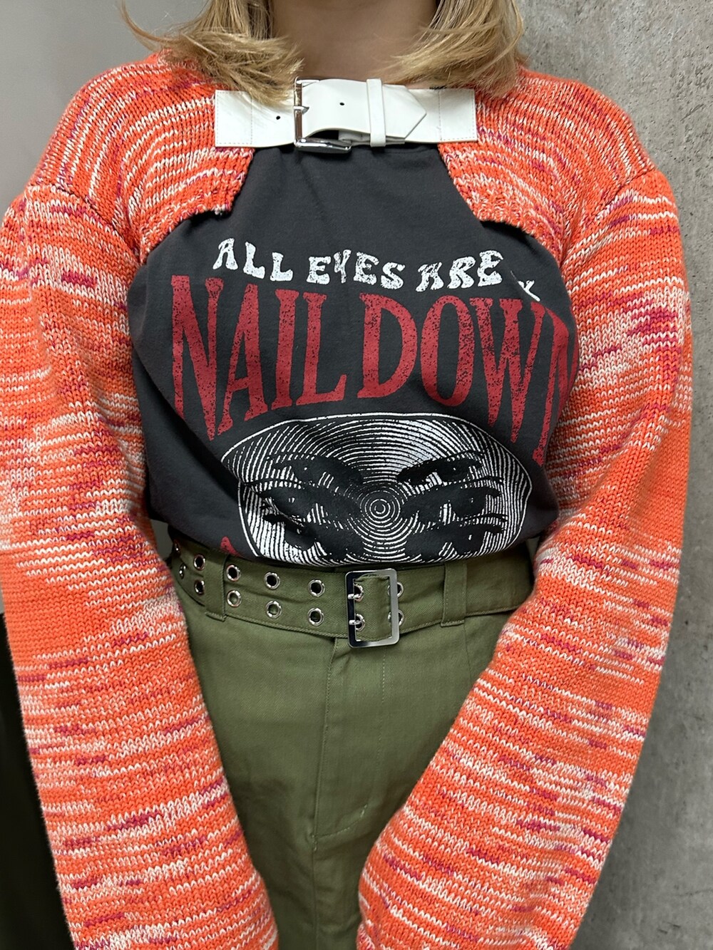 オレンジ系のニット/セーター、ブラック系のTシャツ/カットソー、ベージュ系のスカートを着用したレディースの冬コーディネートの6枚目の写真