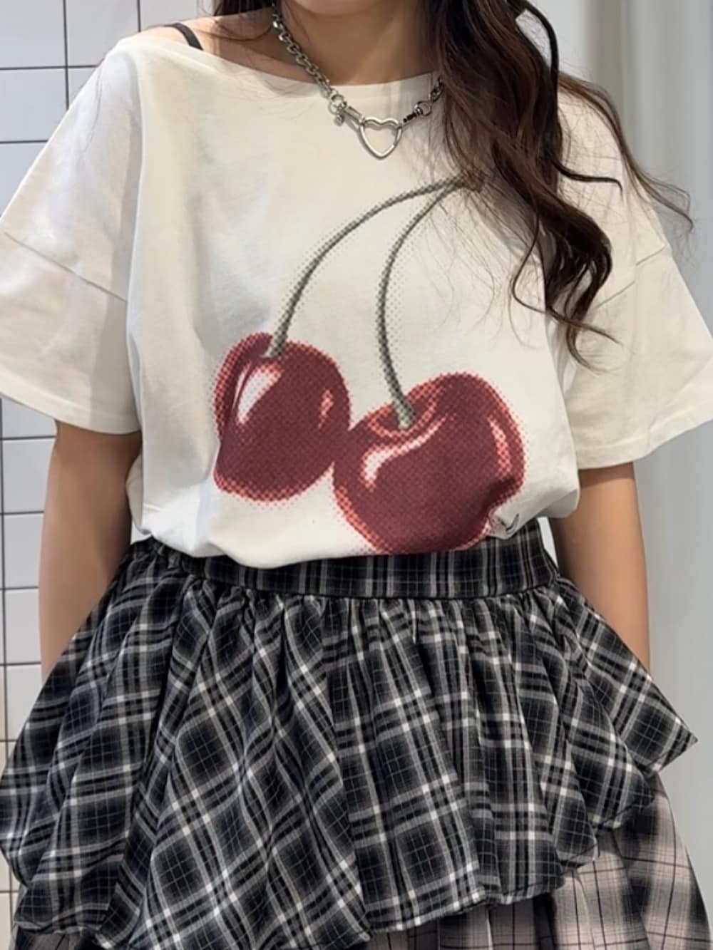 ブラック系のスカート、ブラック系のブーツ、ホワイト系のTシャツ/カットソーを着用したレディースの春コーディネートの7枚目の写真