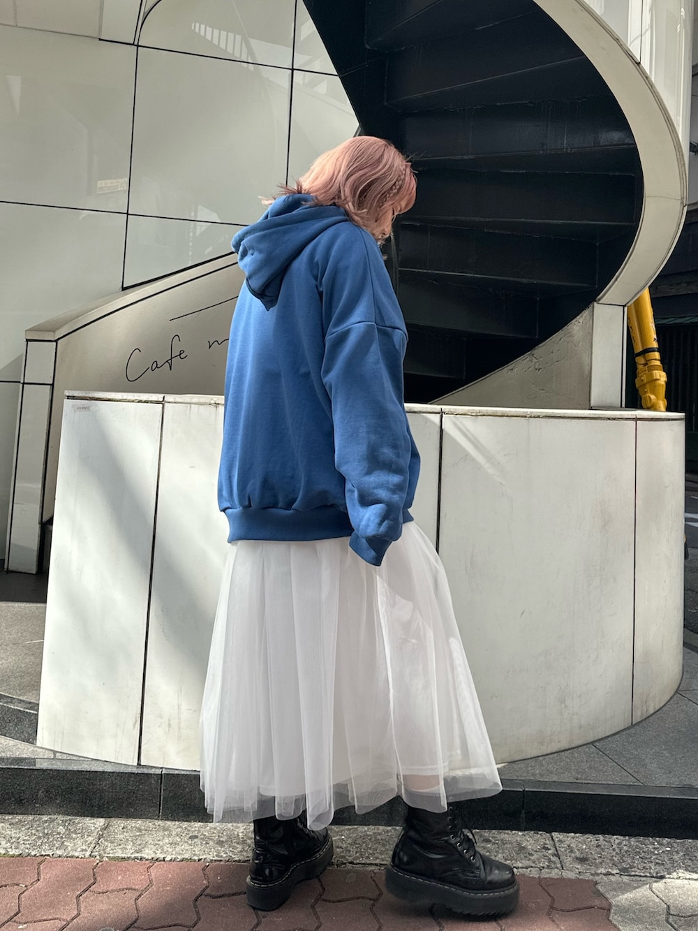 ブルー系のパーカー、ホワイト系のスカート、ブラック系のブーツを着用したレディースの春コーディネートの3枚目の写真