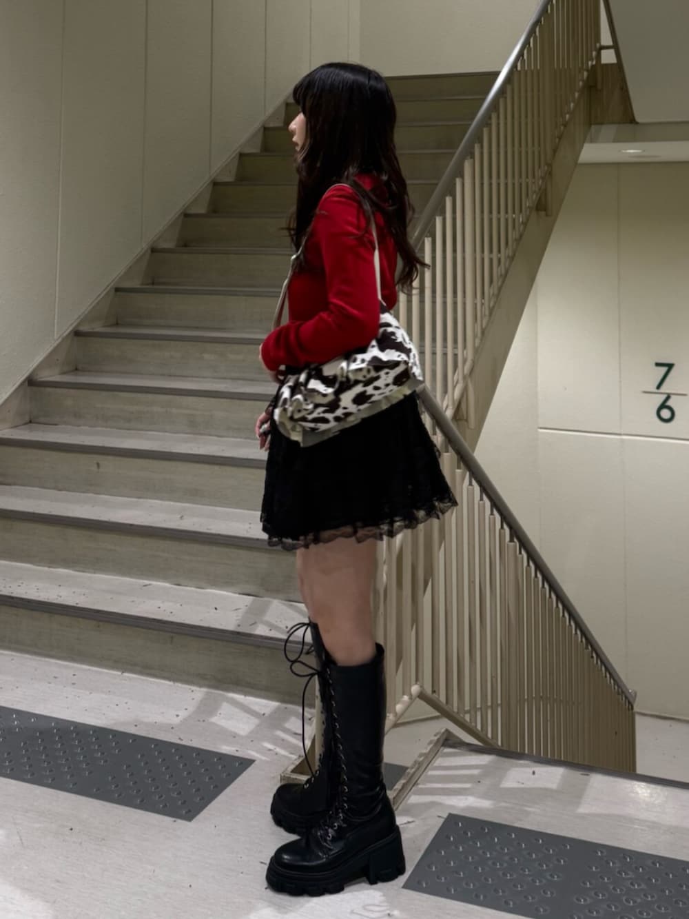 ブラック系のブーツ、ホワイト系のハンドバッグ、ブラック系のその他パンツを着用したレディースの春コーディネートの4枚目の写真