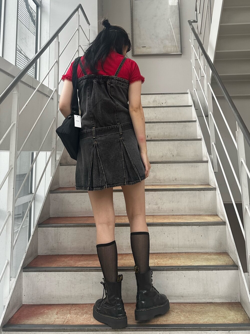 レッド系のTシャツ/カットソー、ブラック系のワンピース、ブラック系のショルダーバッグを着用したレディースの夏コーディネートの3枚目の写真