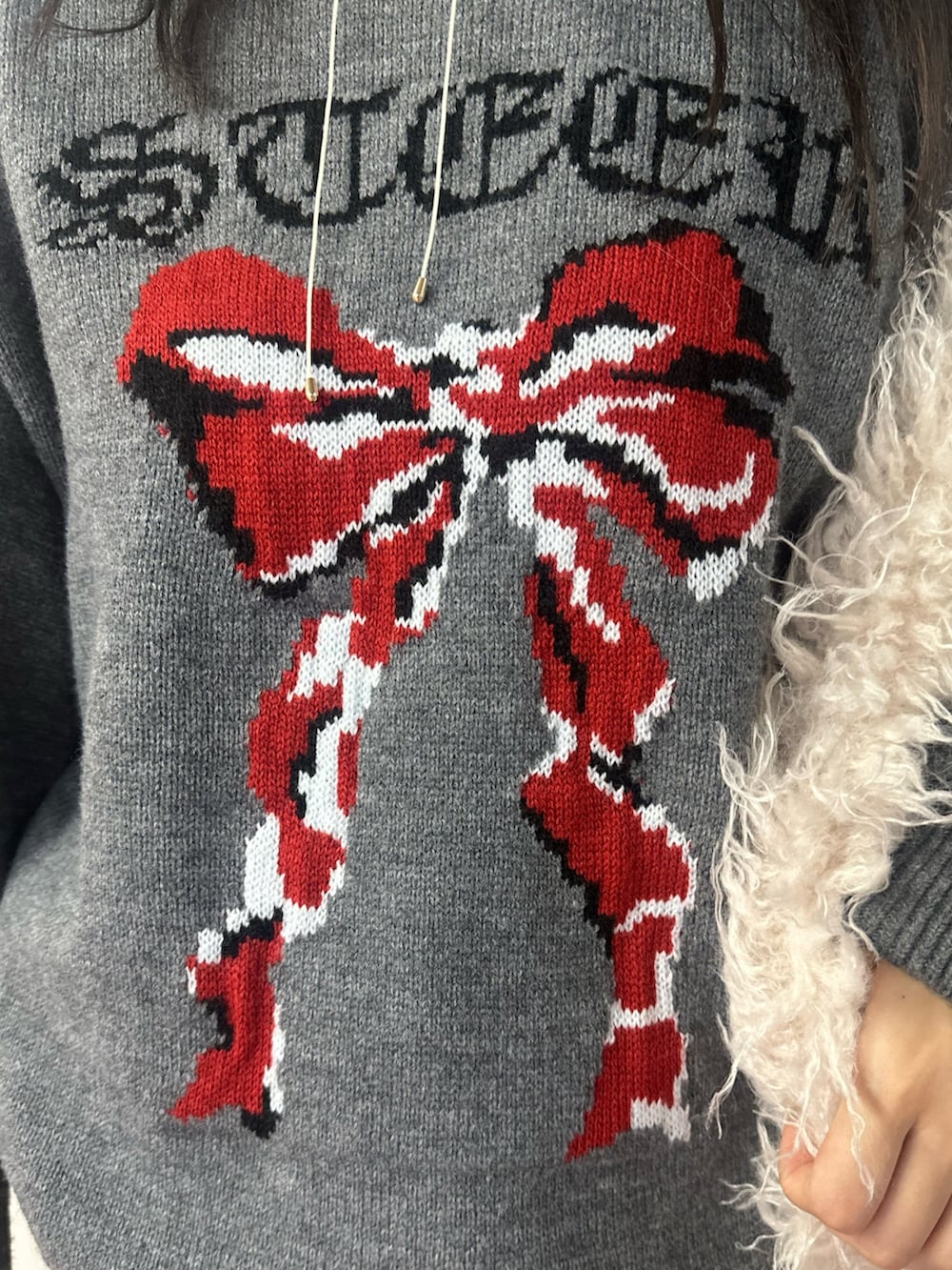 ホワイト系のショルダーバッグ、グレー系のニット/セーター、ブラウン系のその他パンツを着用したレディースの冬コーディネートの6枚目の写真