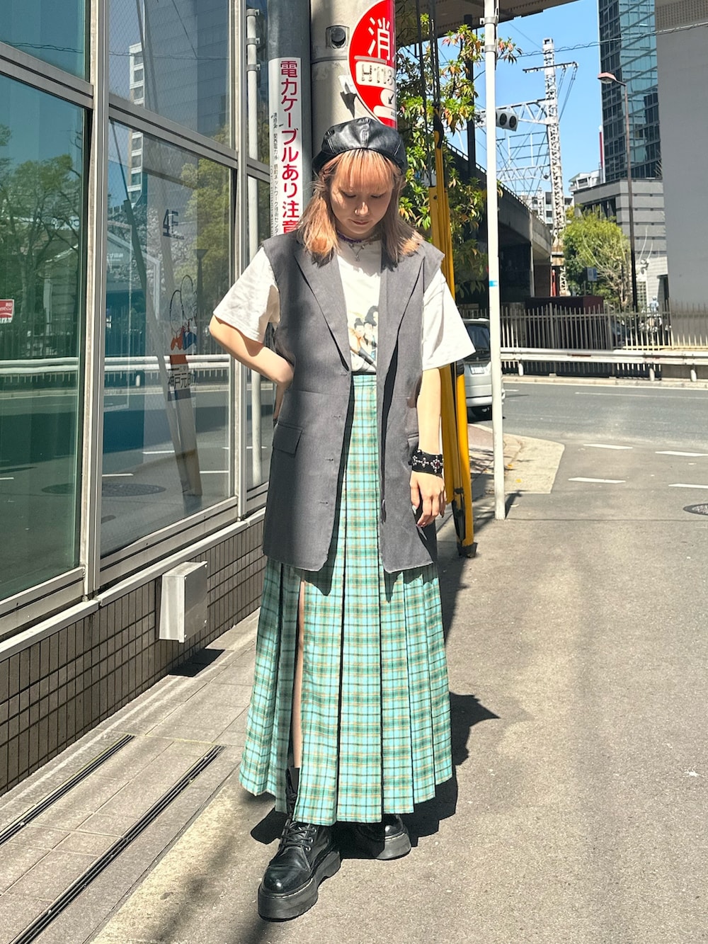 グリーン系のスカート、グレー系のベスト、ホワイト系のTシャツ/カットソーを着用したレディースの春コーディネートの2枚目の写真