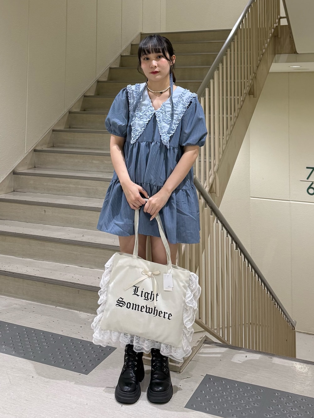 ブルー系のワンピース、ブラック系のブーツ、ホワイト系のトートバッグを着用したレディースの春コーディネートの6枚目の写真