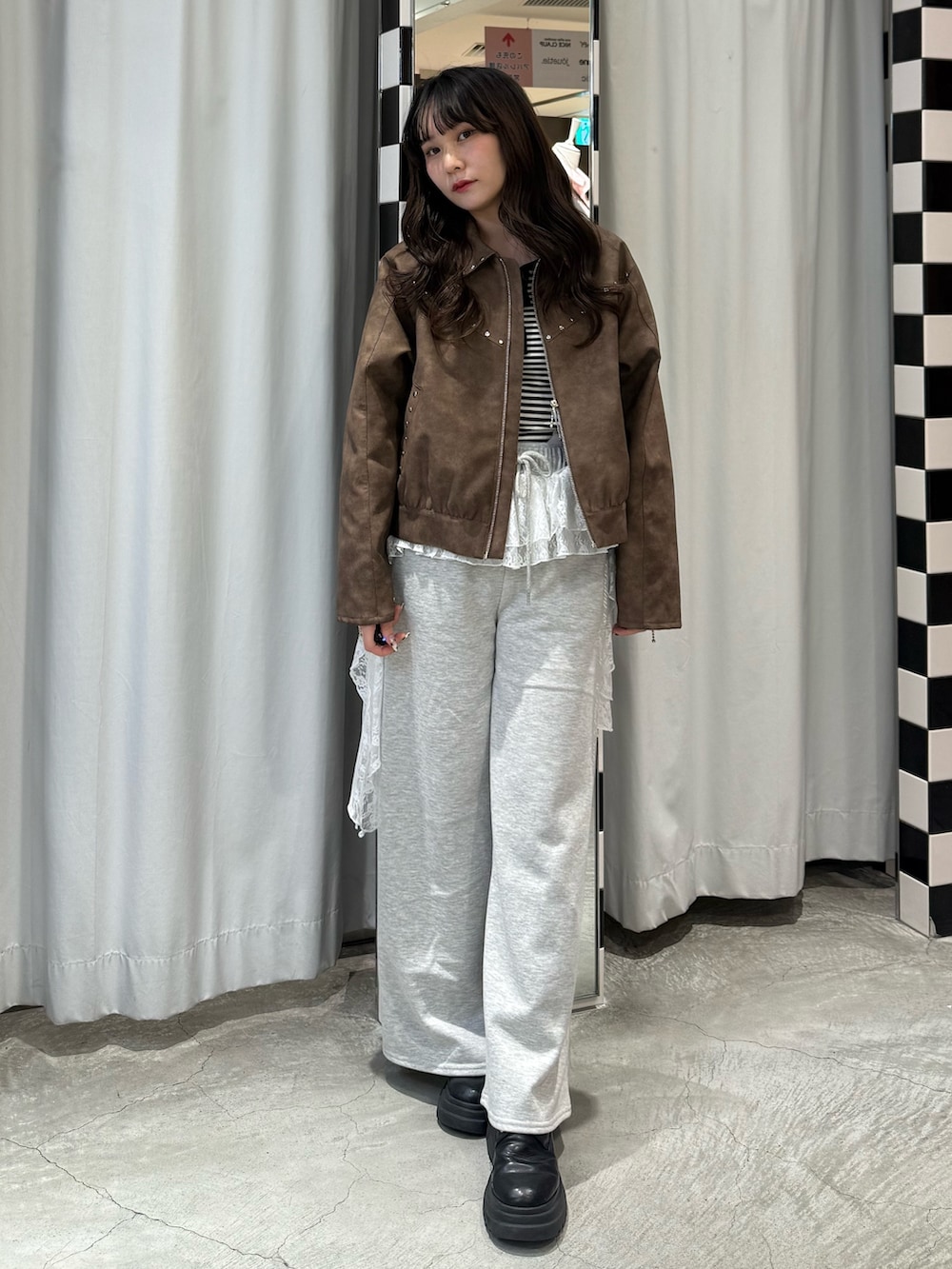 ブラック系のニット/セーター、ブラウン系のブルゾン、グレー系のスウェットパンツを着用したレディースの冬コーディネートの6枚目の写真