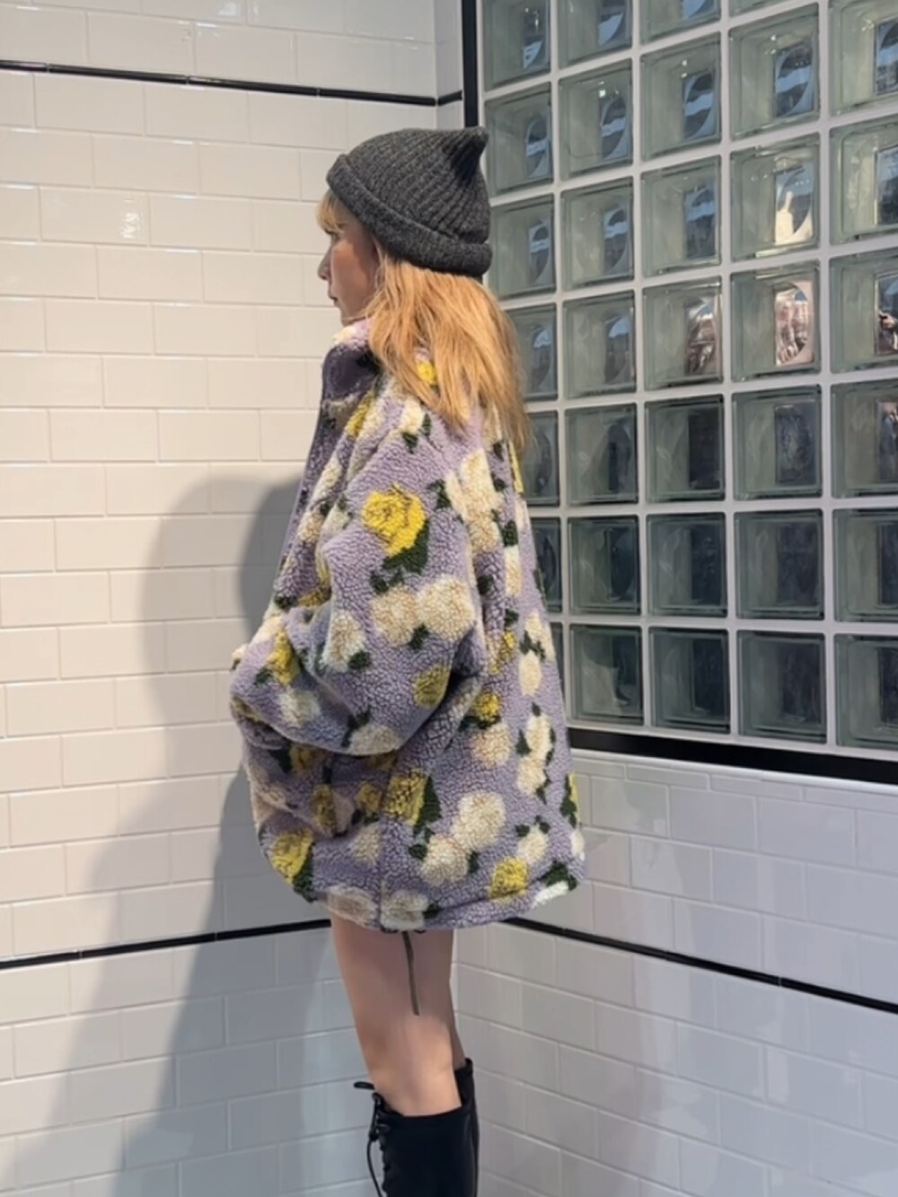 ブラック系のスウェット、パープル系のブルゾン、ブラック系のブーツを着用したレディースの秋コーディネートの2枚目の写真