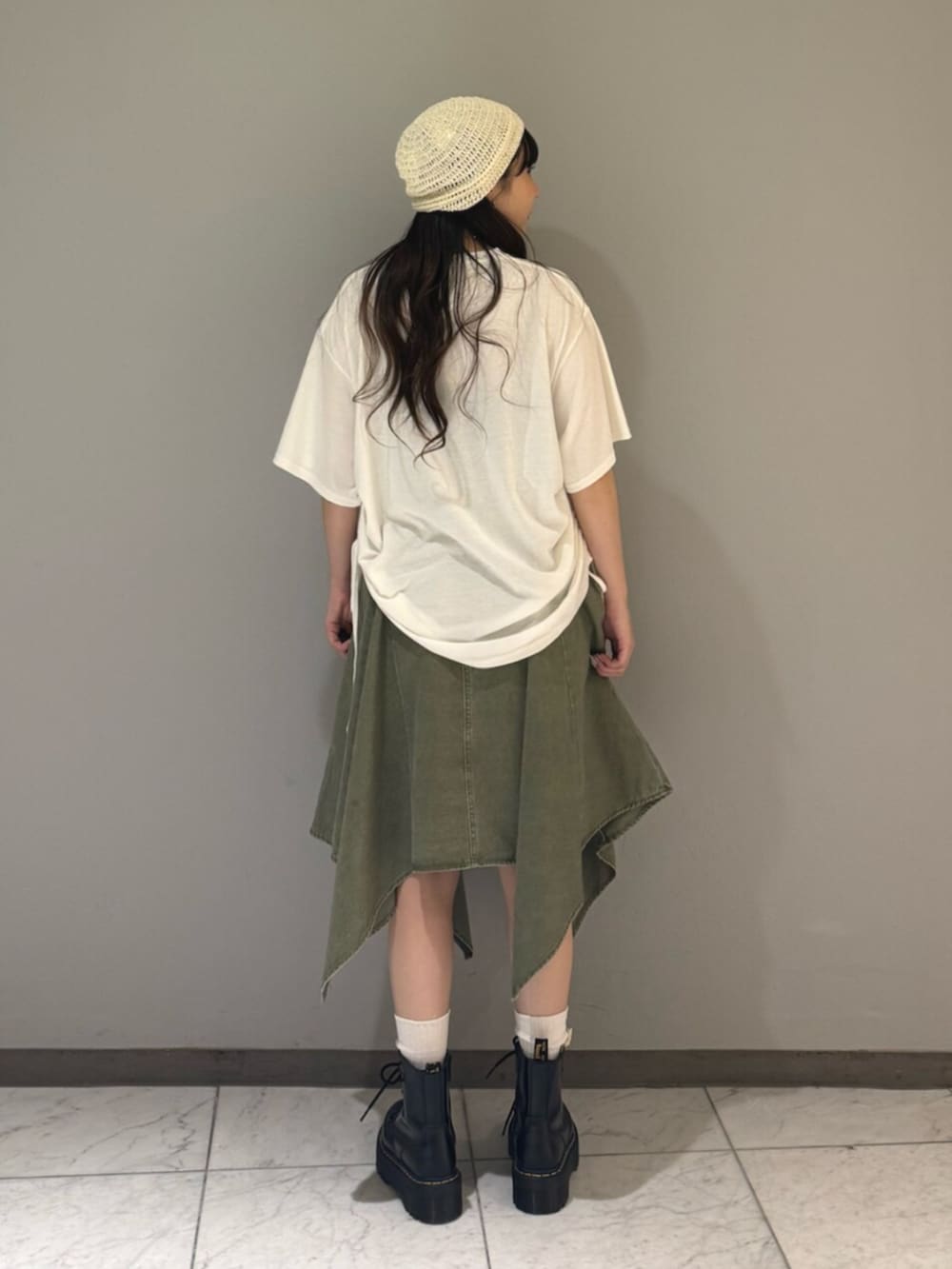 ホワイト系のTシャツ/カットソー、グリーン系のスカート、ホワイト系のニットキャップ/ビーニーを着用したレディースの夏コーディネートの3枚目の写真