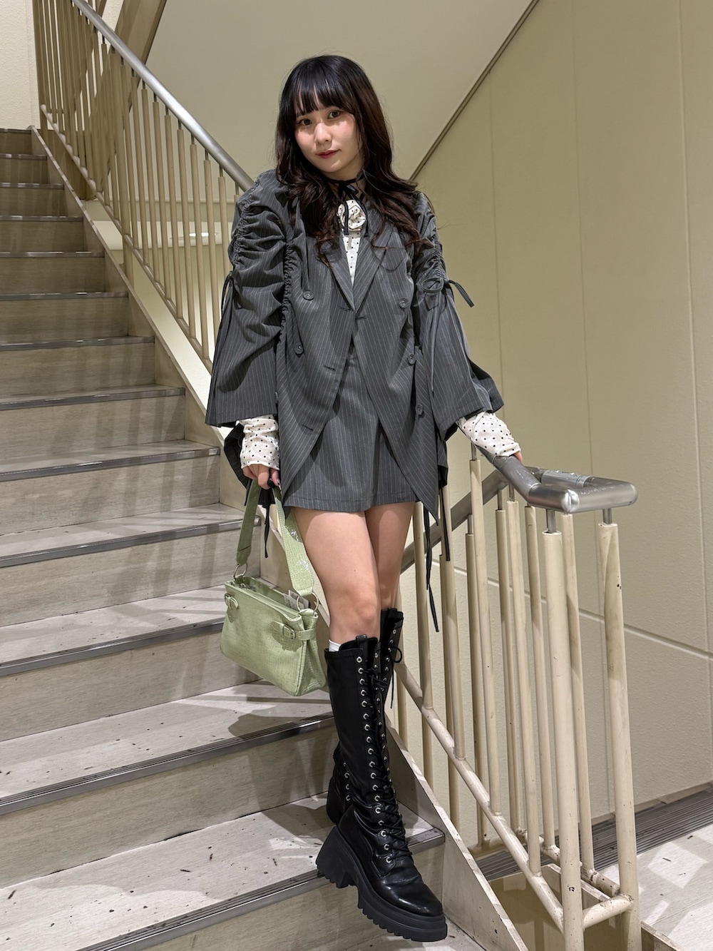 ホワイト系のTシャツ/カットソー、グレー系のスカート、グレー系のテーラードジャケットを着用したレディースの冬コーディネートの6枚目の写真