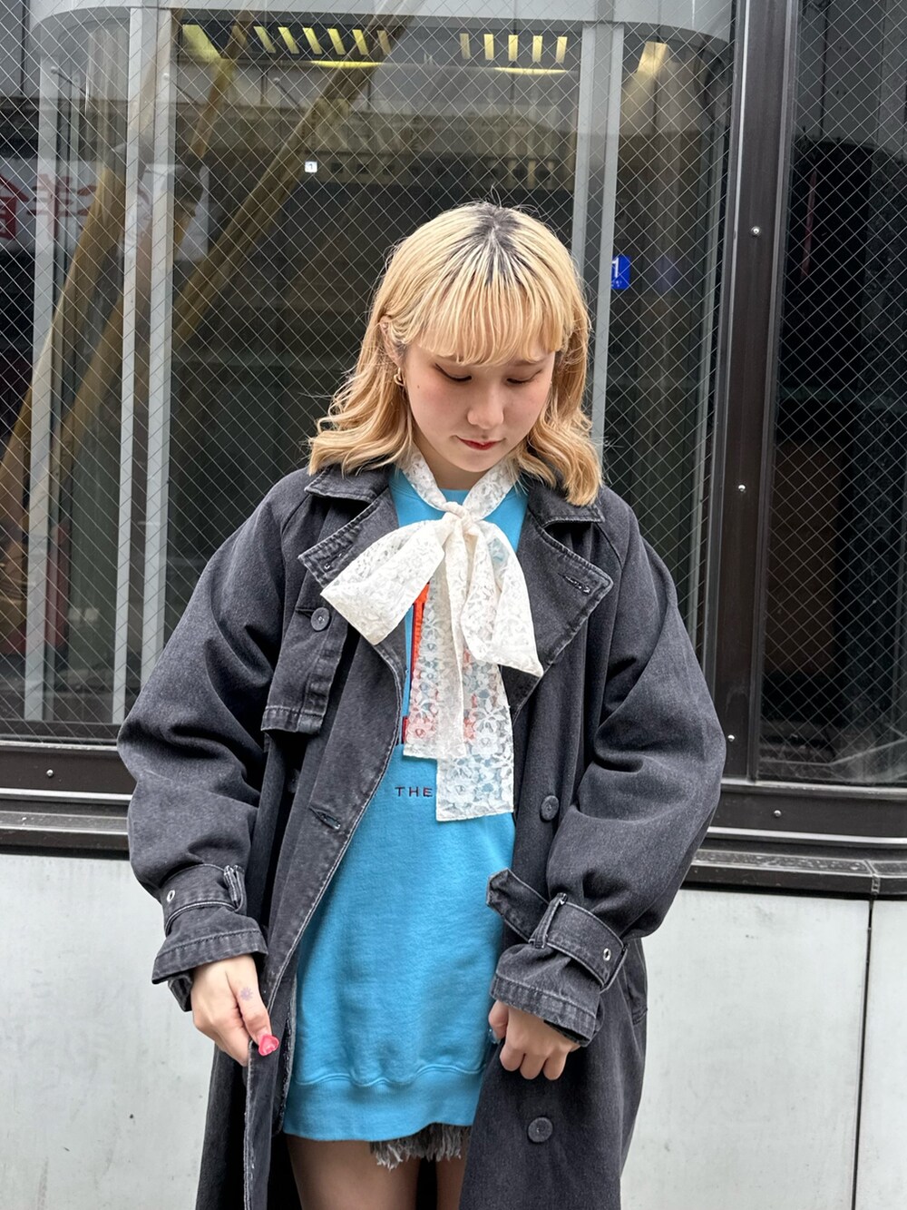 ブラウン系のブーツ、ブラック系のトレンチコート、ブルー系のスウェットを着用したレディースの冬コーディネートの4枚目の写真