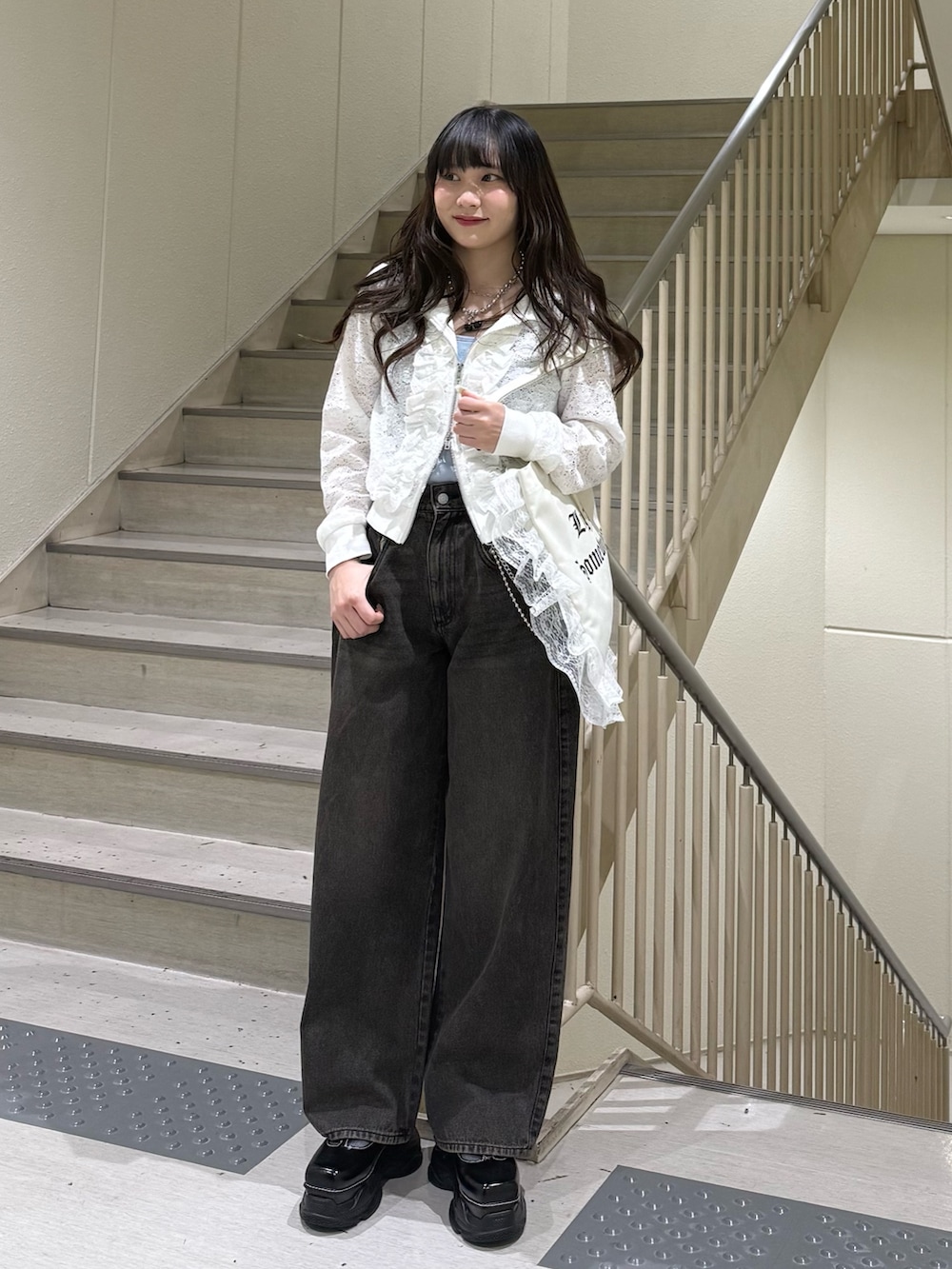 ホワイト系のパーカー、ブラック系のデニムパンツ、ホワイト系のトートバッグを着用したレディースの春コーディネートの5枚目の写真