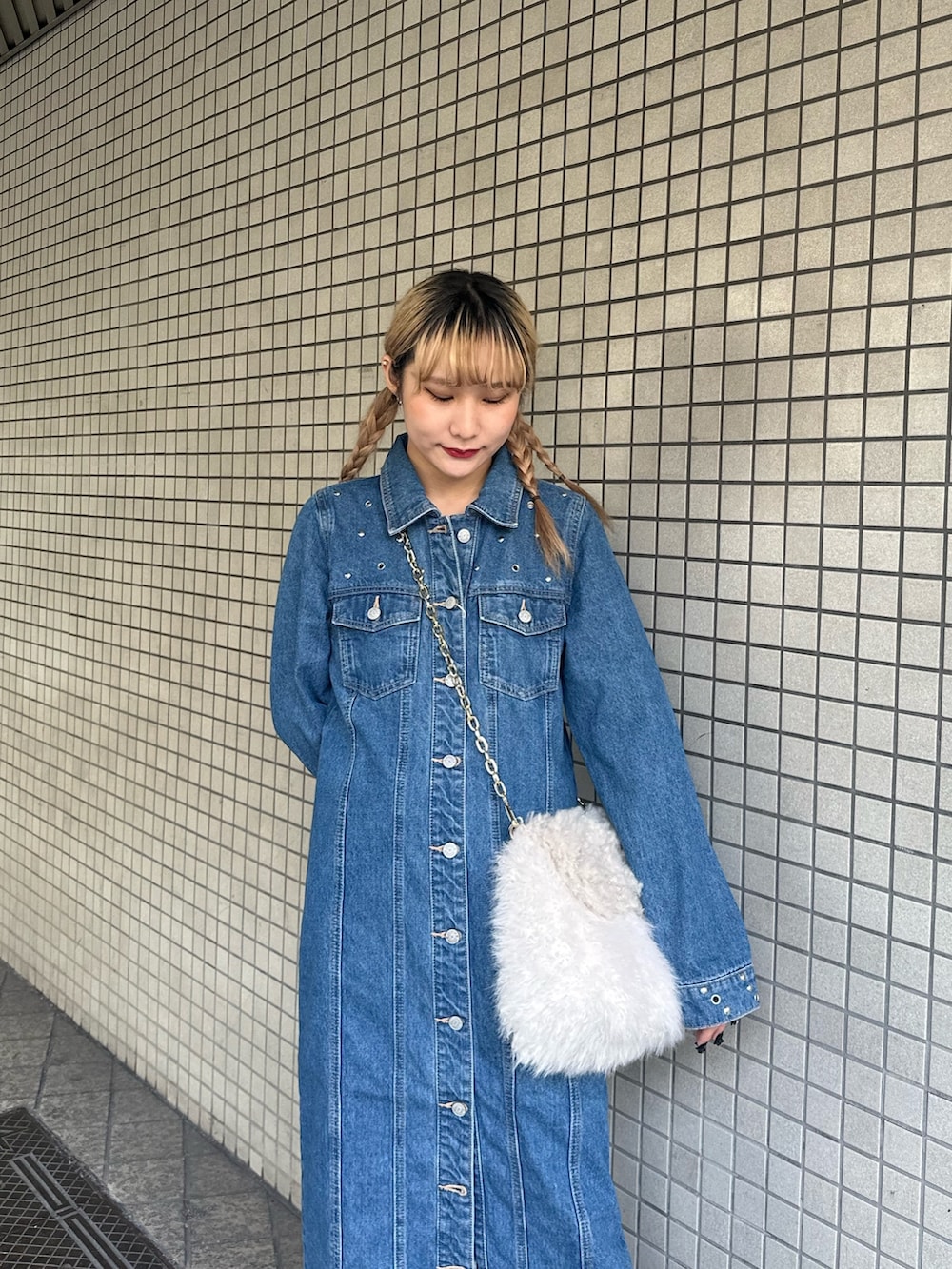 ブルー系のワンピース、ホワイト系のハンドバッグ、ブラック系のブーツを着用したレディースの冬コーディネートの4枚目の写真