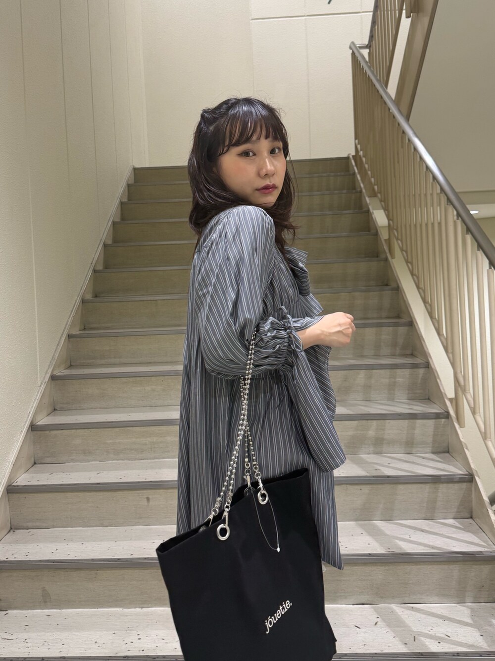 グレー系のシャツ/ブラウス、ブラック系のトートバッグ、ブルー系のブーツを着用したレディースの夏コーディネートの7枚目の写真