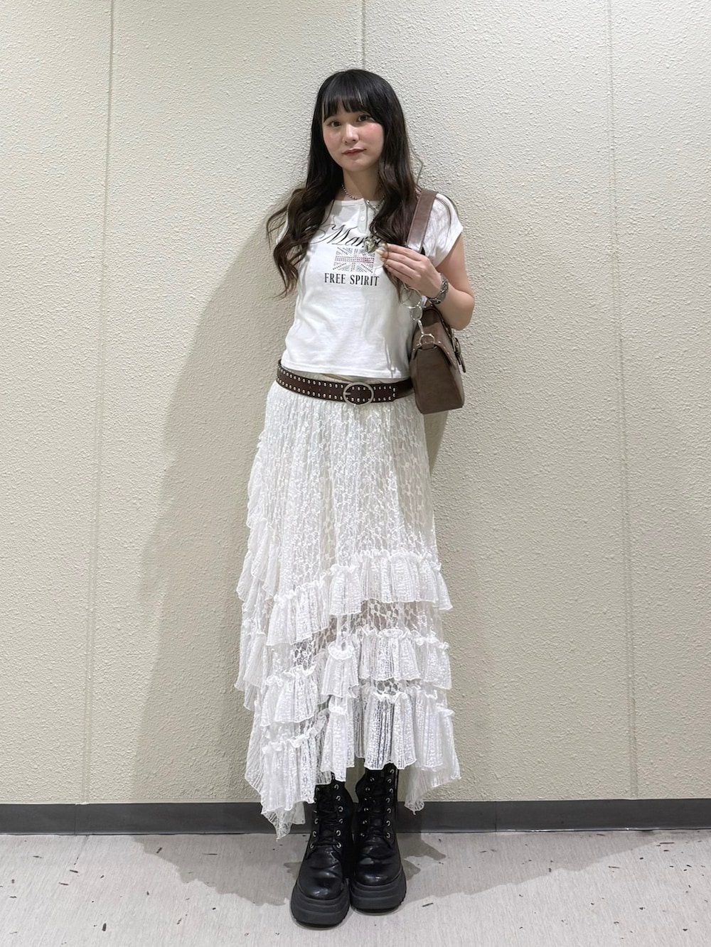 ブラック系のブーツ、ホワイト系のスカート、ホワイト系のTシャツ/カットソーを着用したレディースの春コーディネートの4枚目の写真