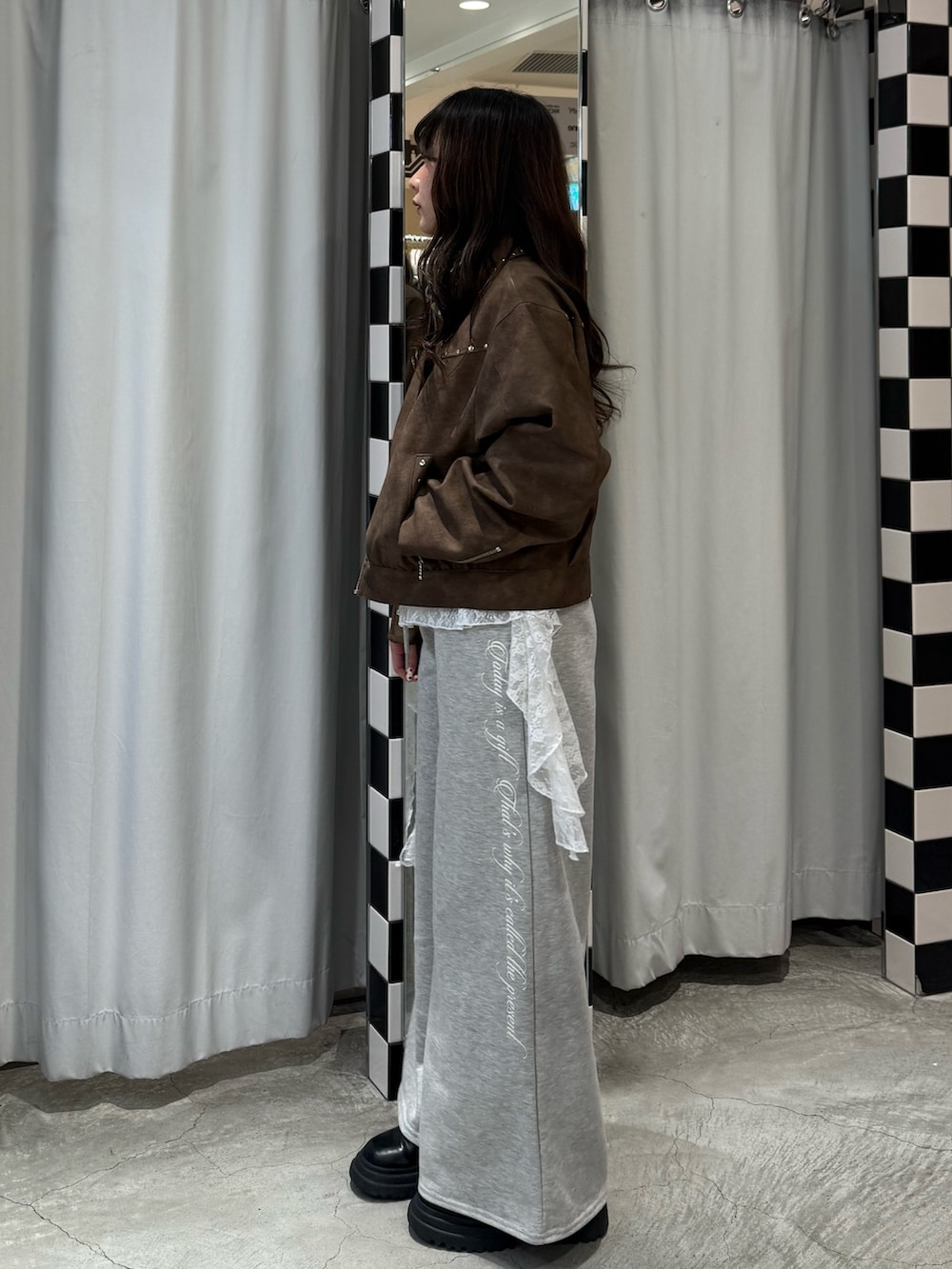 ブラック系のニット/セーター、ブラウン系のブルゾン、グレー系のスウェットパンツを着用したレディースの冬コーディネートの3枚目の写真