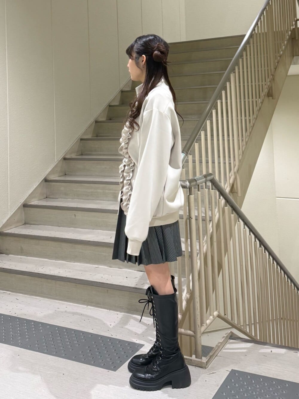 ブラック系のブーツ、ホワイト系のジャージ、その他のスカートを着用したレディースの冬コーディネートの4枚目の写真