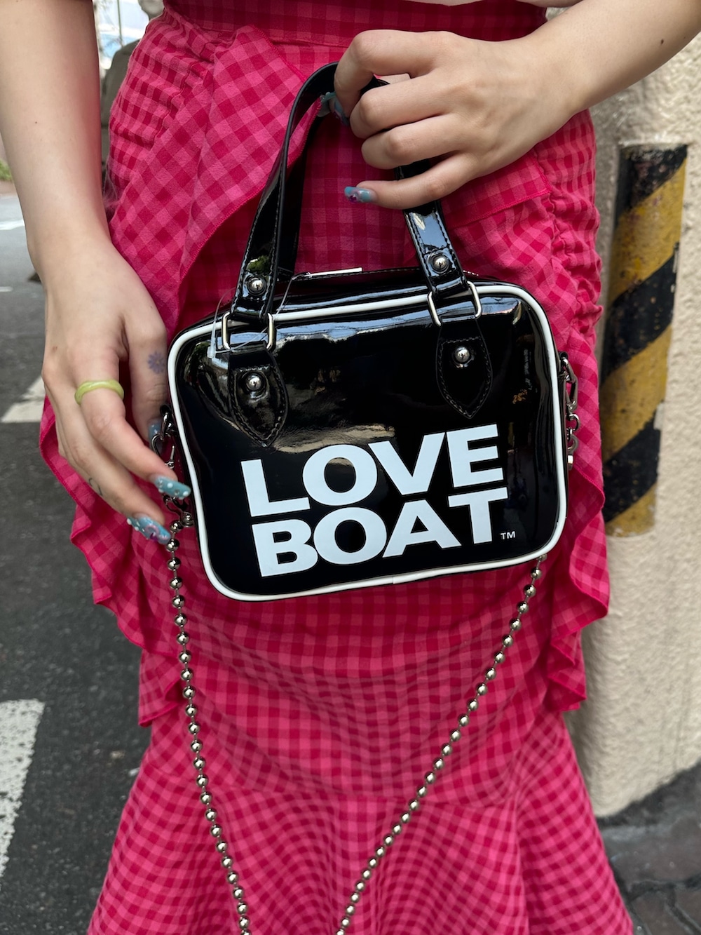 ブラック系のブーツ、ホワイト系のTシャツ/カットソー、ピンク系のスカートを着用したレディースの春コーディネートの7枚目の写真
