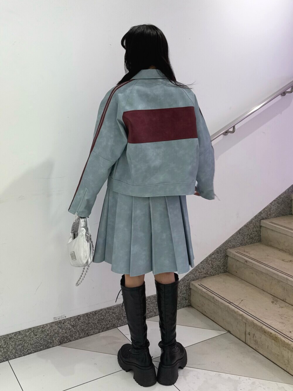 ブラック系のブーツ、ブルー系のブルゾン、ブルー系のスカートを着用したレディースの冬コーディネートの3枚目の写真