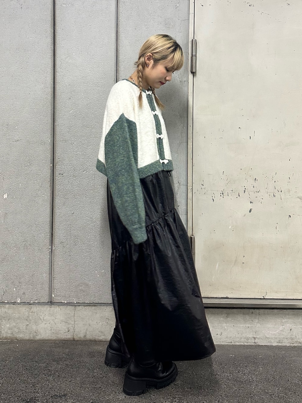 ホワイト系のカーディガン/ボレロ、ブラック系のスカート、ブラック系のブーツを着用したレディースの秋コーディネートの2枚目の写真