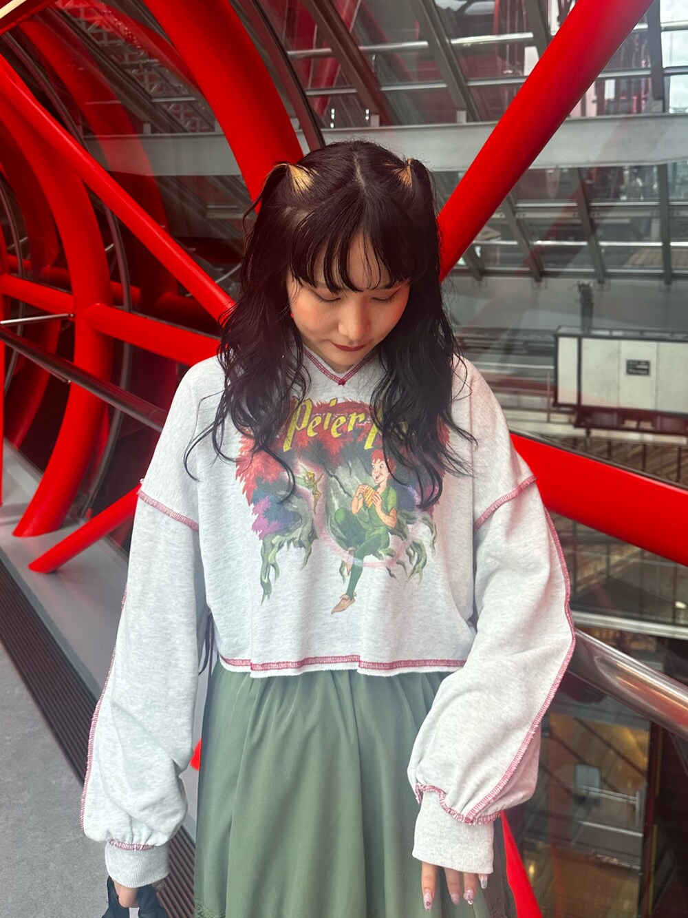 グレー系のスウェット、グリーン系のスカート、ブラック系のショルダーバッグを着用したレディースの夏コーディネートの5枚目の写真