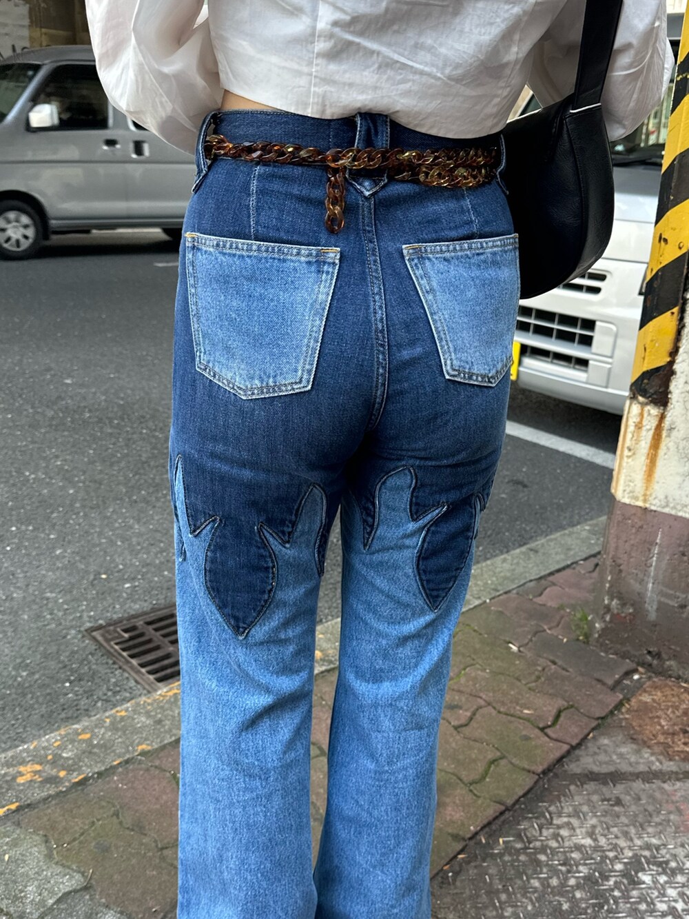 ホワイト系のシャツ/ブラウス、ブルー系のデニムパンツ、ブラック系のショルダーバッグを着用したレディースの春コーディネートの7枚目の写真