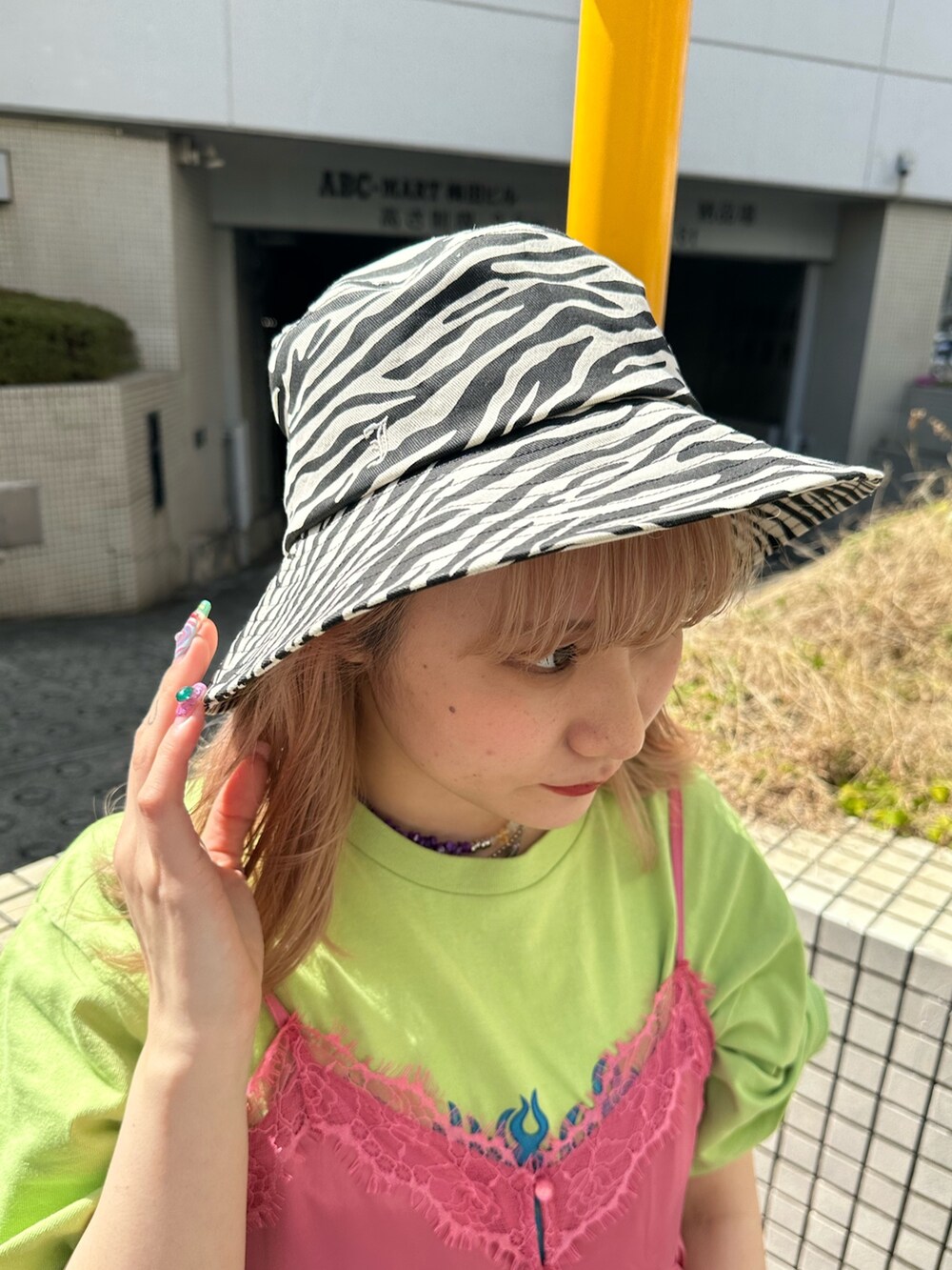 グリーン系のTシャツ/カットソー、ブルー系のデニムパンツ、ピンク系のワンピースを着用したレディースの春コーディネートの7枚目の写真