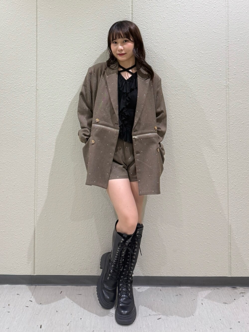 ブラック系のブーツ、ブラウン系のテーラードジャケット、ブラウン系のその他パンツを着用したレディースの秋コーディネートの2枚目の写真