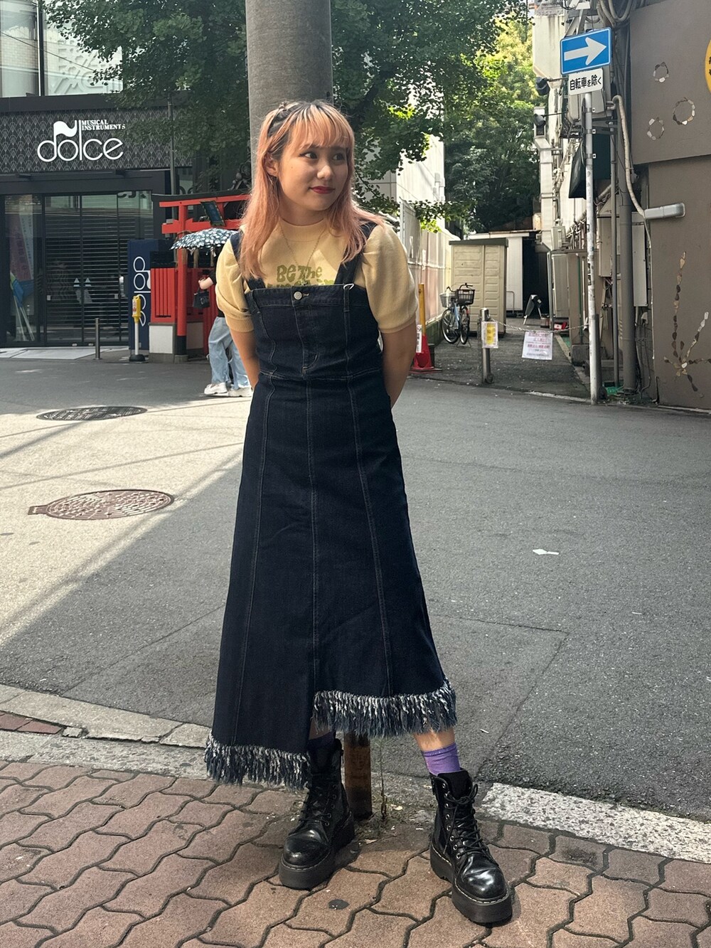 ブルー系のジャンパースカート、ホワイト系のニット/セーター、ブラック系のMA-1を着用したレディースの夏コーディネートの4枚目の写真