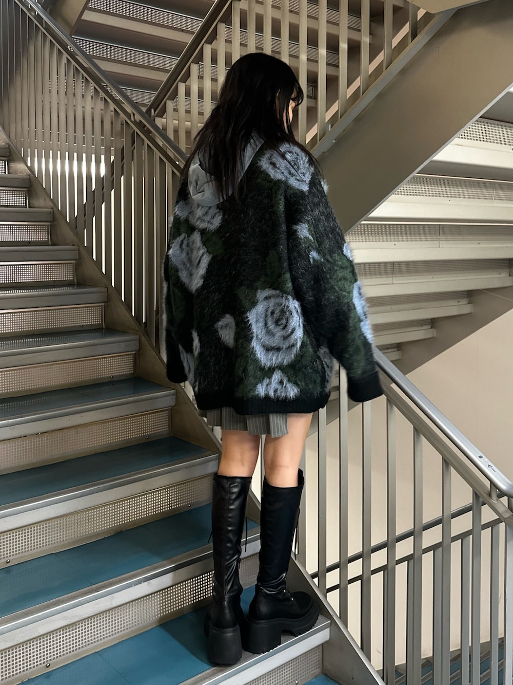 グレー系のスカート、ブラック系のニット/セーター、ブルー系のシャツ/ブラウスを着用したレディースの秋コーディネートの4枚目の写真