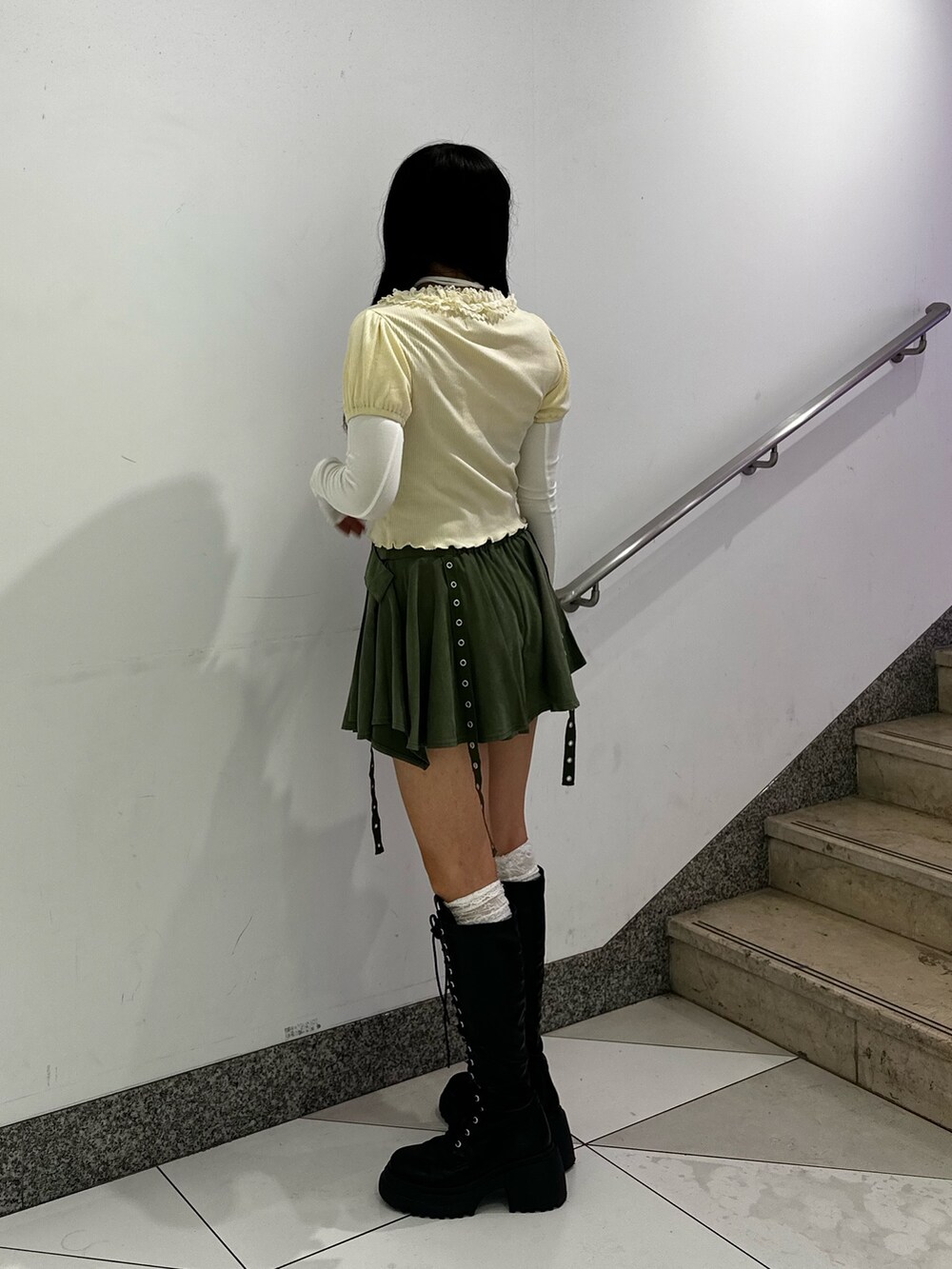 ホワイト系のTシャツ/カットソー、グリーン系のスカート、ブラック系のブーツを着用したレディースの秋コーディネートの4枚目の写真