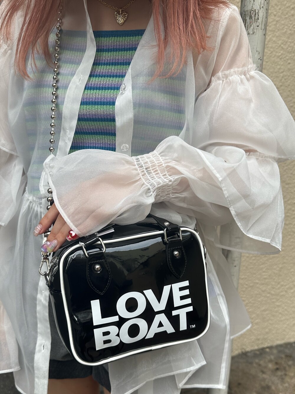 ブラック系のブーツ、ブラック系のデニムパンツ、ホワイト系のシャツ/ブラウスを着用したレディースの夏コーディネートの7枚目の写真