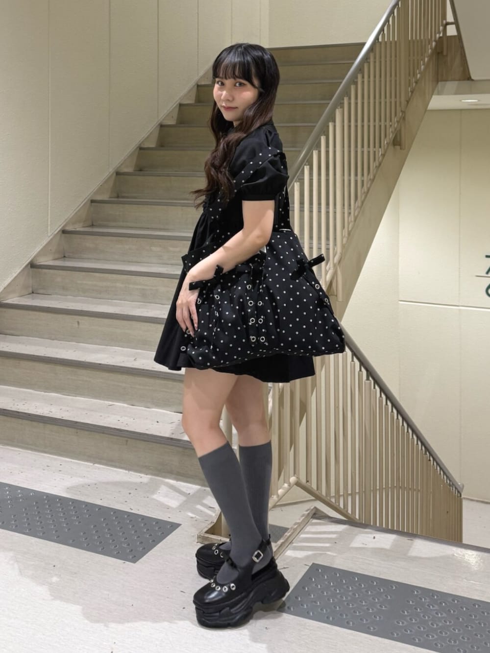 ブラック系のパンプス、ブラック系のワンピース、その他のトートバッグを着用したレディースの夏コーディネートの2枚目の写真