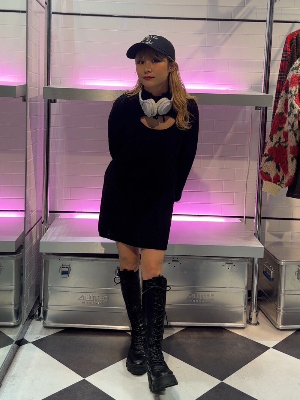 ブラック系のワンピース、ブラック系のブーツ、ブラック系のキャップを着用したレディースの冬コーディネートの2枚目の写真