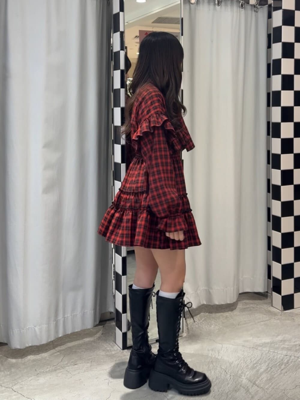 ブラック系のブーツ、レッド系のワンピースを着用したレディースの冬コーディネートの4枚目の写真