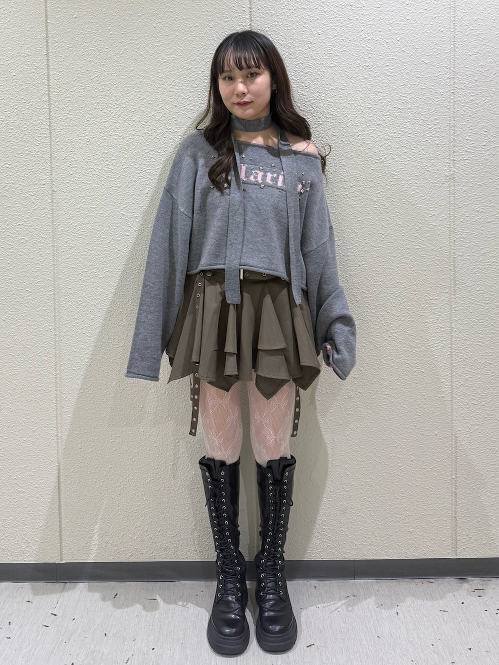 ベージュ系のスカート、グレー系のニット/セーター、ブラック系のブーツを着用したレディースの冬コーディネートの5枚目の写真