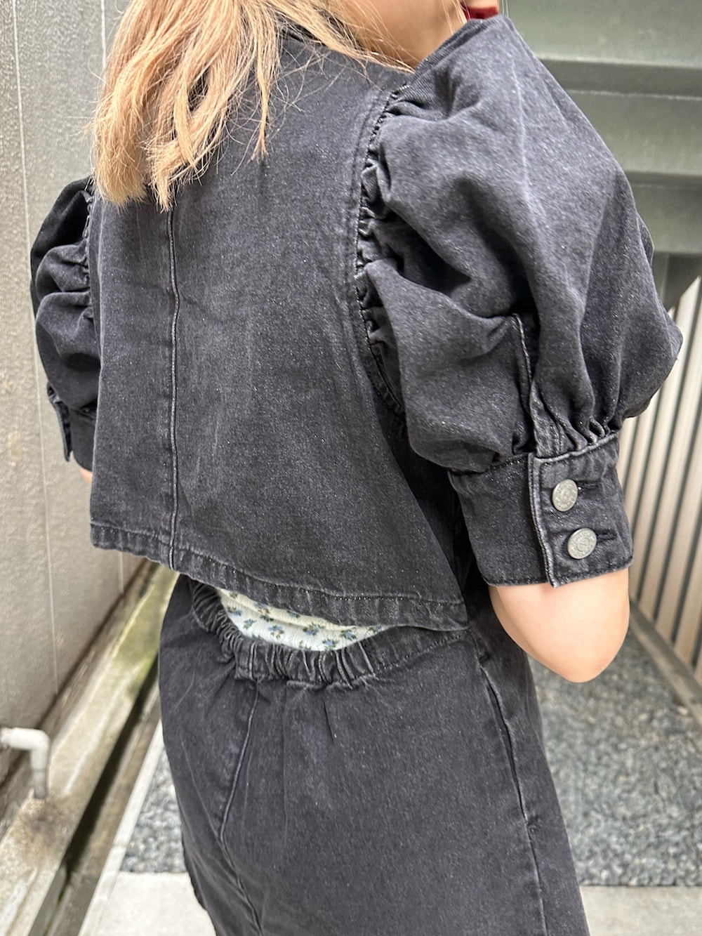 ブラック系のワンピース、ブラック系のハンドバッグ、ゴールド系のピアス（両耳用）を着用したレディースの春コーディネートの7枚目の写真