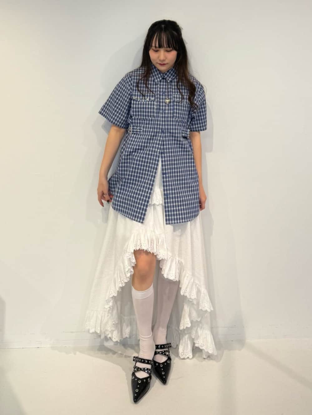 ブラック系のパンプス、ブルー系のシャツ/ブラウス、ホワイト系のスカートを着用したレディースの春コーディネートの2枚目の写真