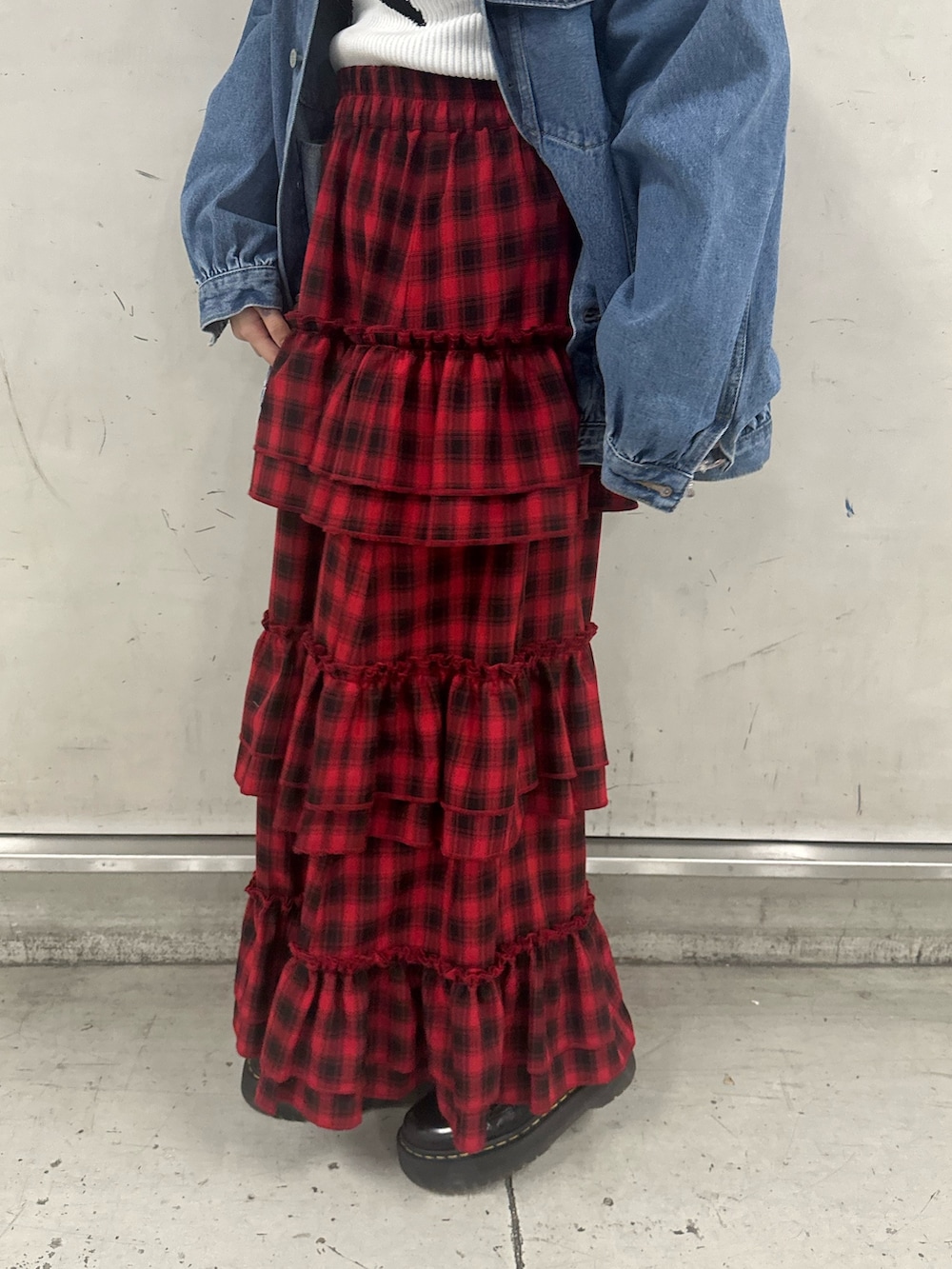 ブルー系のデニムジャケット、ホワイト系のニット/セーター、レッド系のスカートを着用したレディースの春コーディネートの6枚目の写真